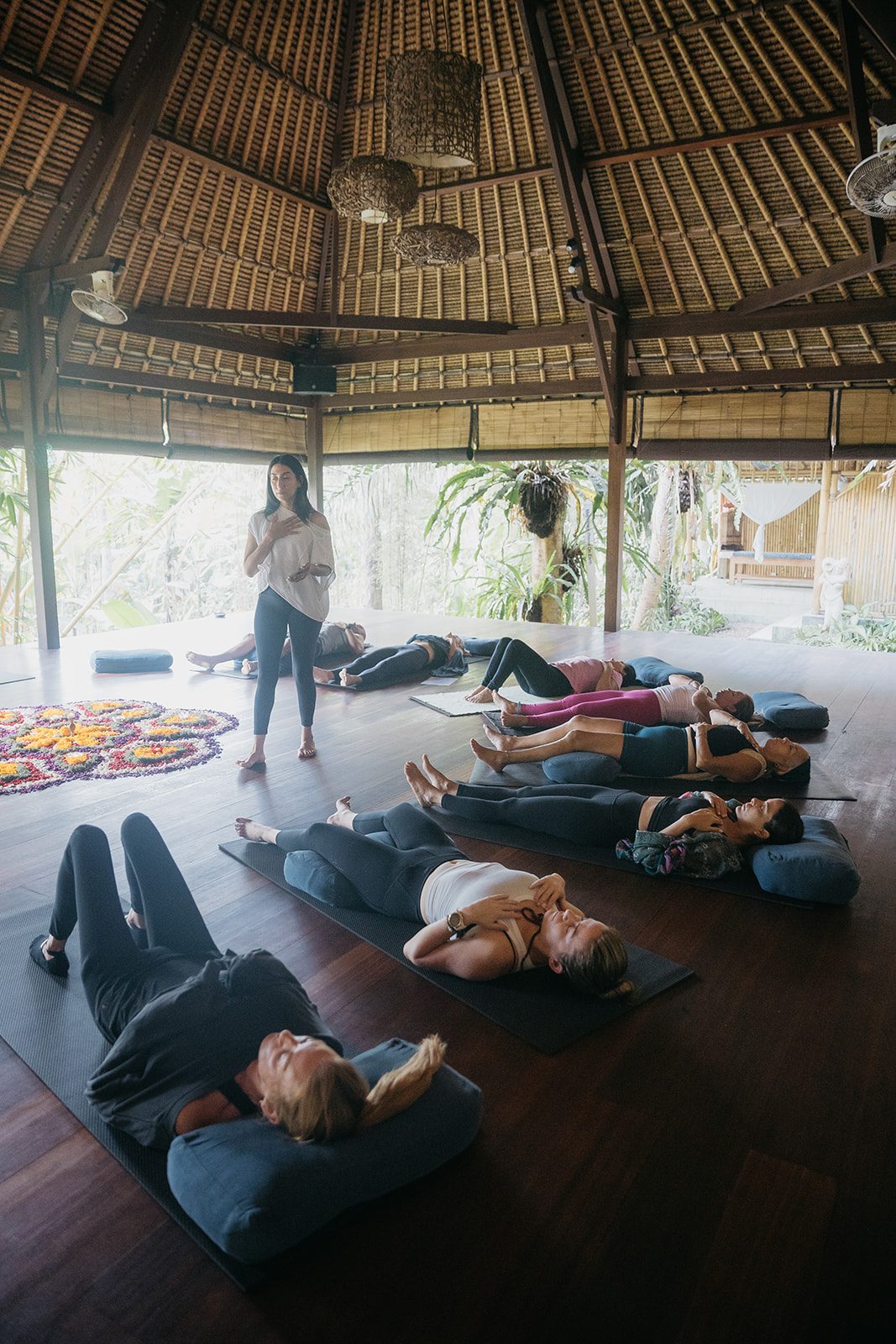 Irene del Valle leading a group meditation in a bamboo pavilion at a Bali retreat