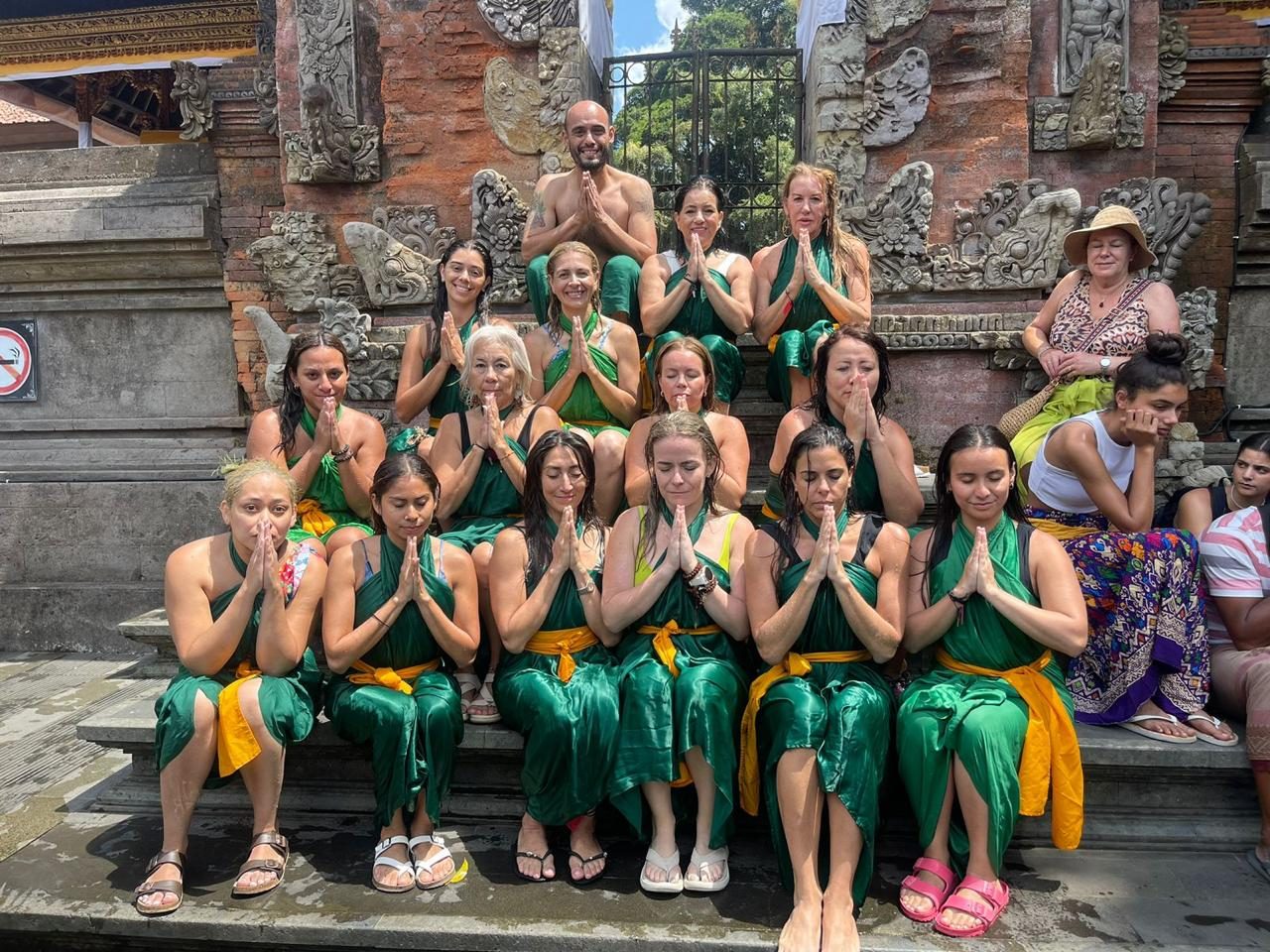 Retreat group in green ceremonial sarongs at a Balinese temple