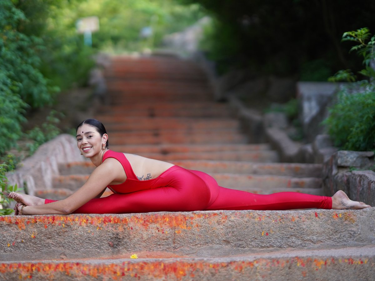 Irene smiling in a full front split on stone steps